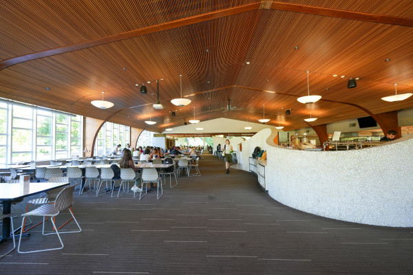 Interior of dining hall with lots of tables.